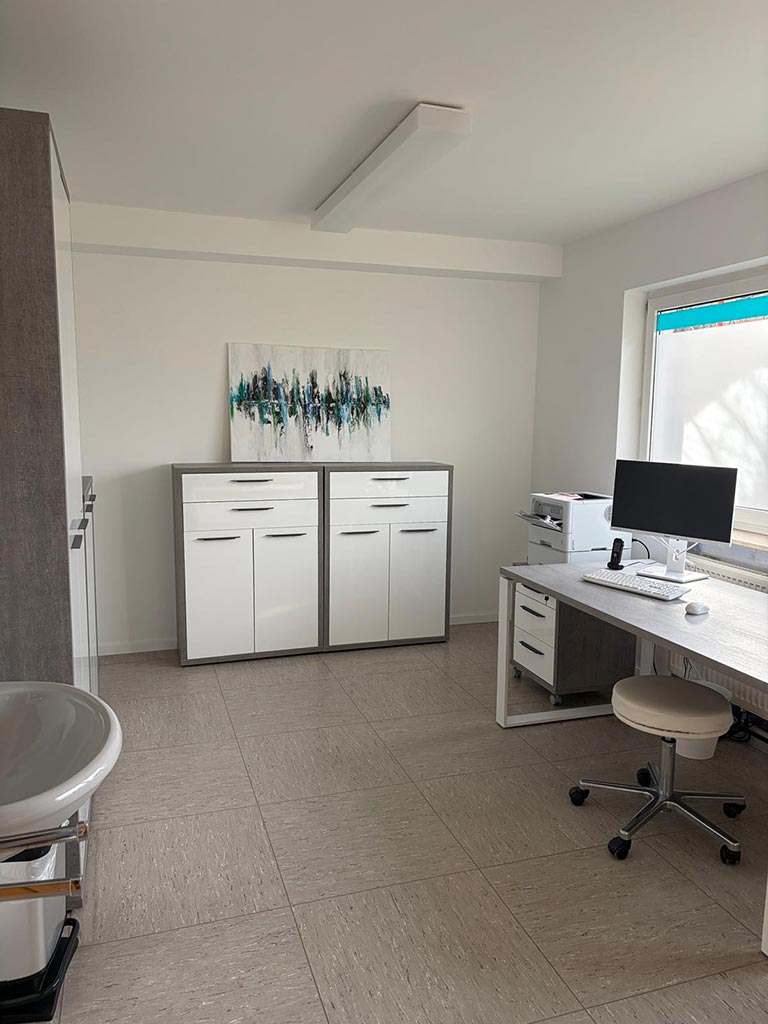 Behandlungszimmer mit Arbeitsplatz in der Hausarztpraxis Rodenbach
